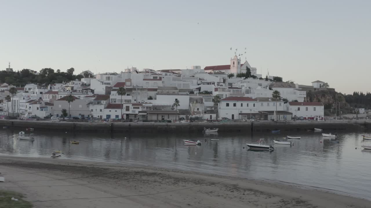 воздушная съемка с грузовика над живописным берегом реки в белой деревне, портиман алгарве