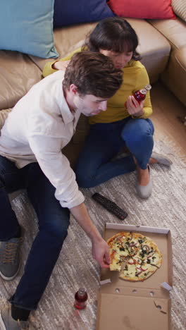 video vertical de una pareja feliz y diversa comiendo pizza