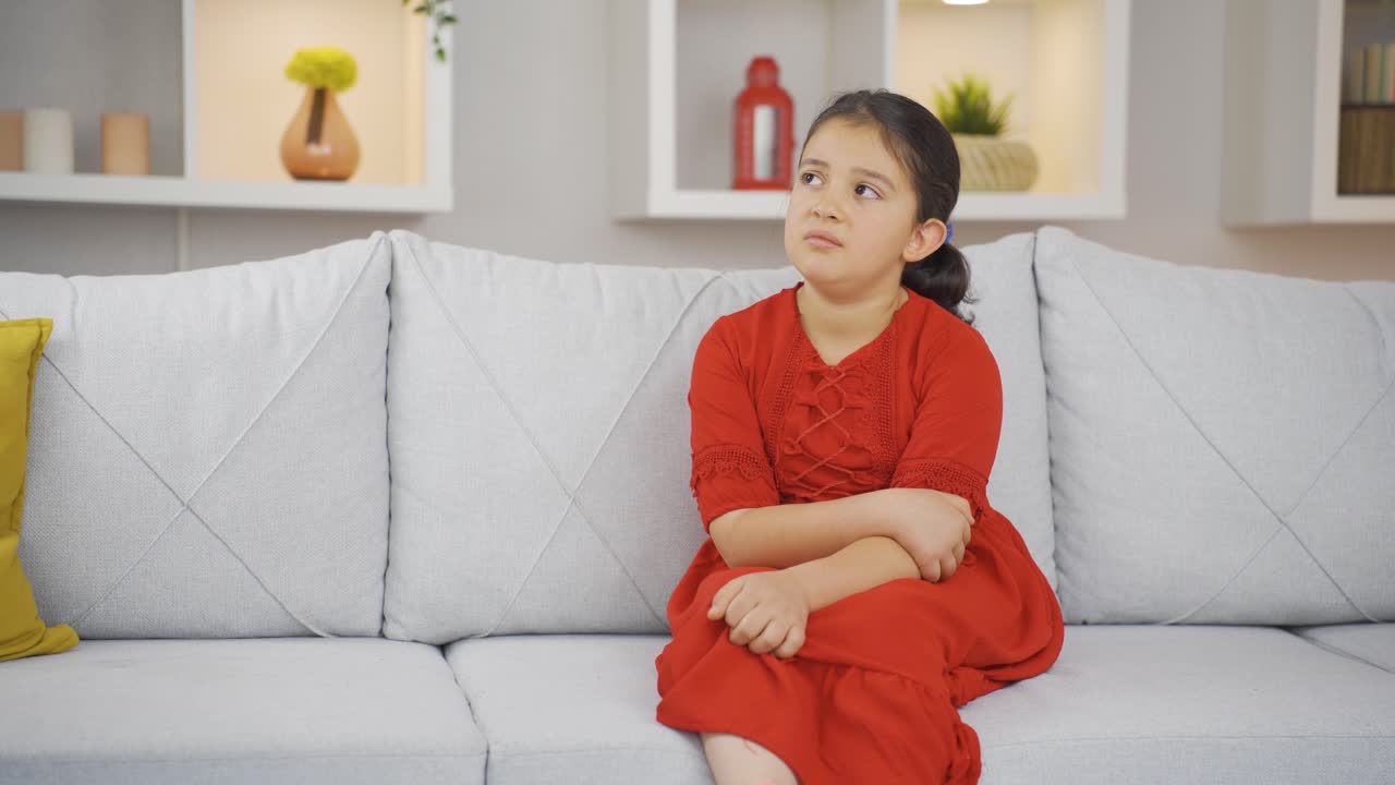 niña en casa mirando a la cámara con una expresión tranquila.