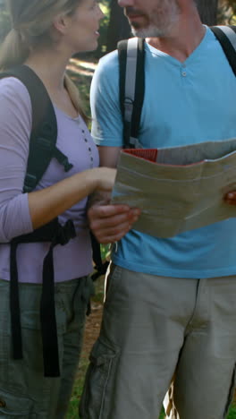 una pareja de excursionistas interactuando mientras miran el mapa