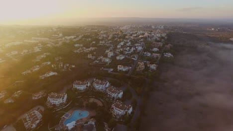 Fog-coming-in-from-the-Atlantic-ocean-during-sunset-at-Luz,-Algarve,-Portugal