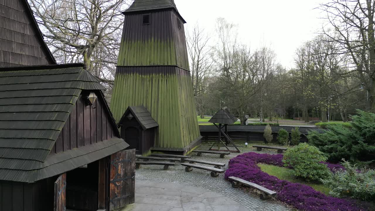 Historic Wooden Bell Tower and Church Building with Purple Flowers