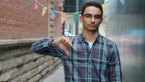 young man giving a thumbs down