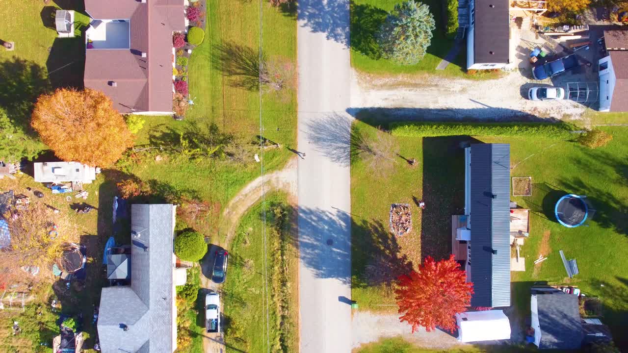 Estrie reveals vivid fall foliage across small Canadian town, top down autumn