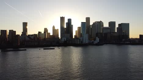 Aerial---Sunset-over-River-Thames-and-Canary-Wharf,-London,-UK,-wide-rising-shot