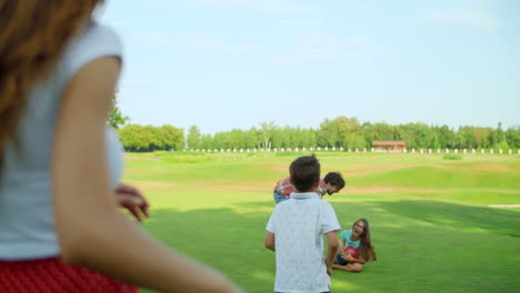 Vater-Spielt-Mit-Tochter-Auf-Der-Wiese.-Frau-Und-Junge-Stehen-Im-Feld