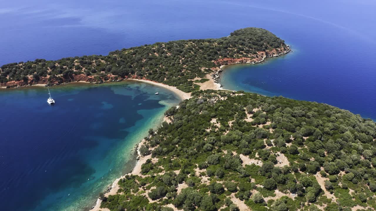 This video represent small island on the sea with few boats near the beach. Footage is taken with drone.