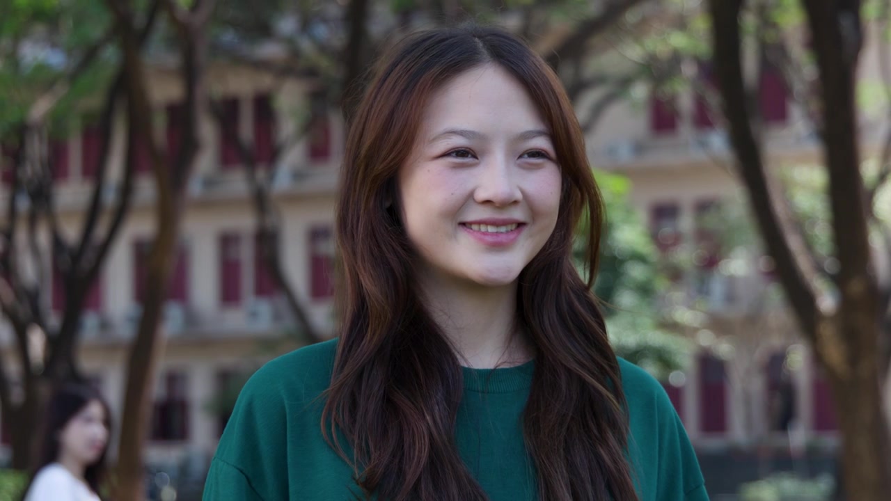 자연광과 흐릿한 도시 배경이 있는 야외에서 미소 짓는 행복한 여성의 미디엄 샷