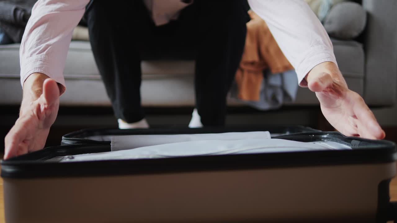 Tourism and travelling concept. Handsome business man going on holiday, packing his suitcase, checking luggage, sitting on bed and looking at packed things