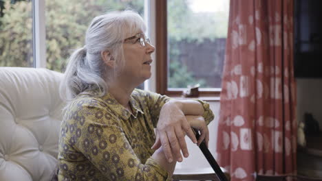 senior woman sitting in a chair by the window