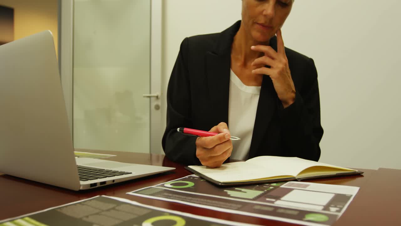 mujer de negocios escribiendo en un diario en el escritorio 4k