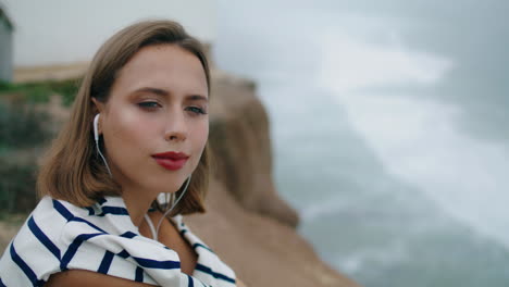 beautiful girl listen music at ocean waves vertical closeup. calm student rest