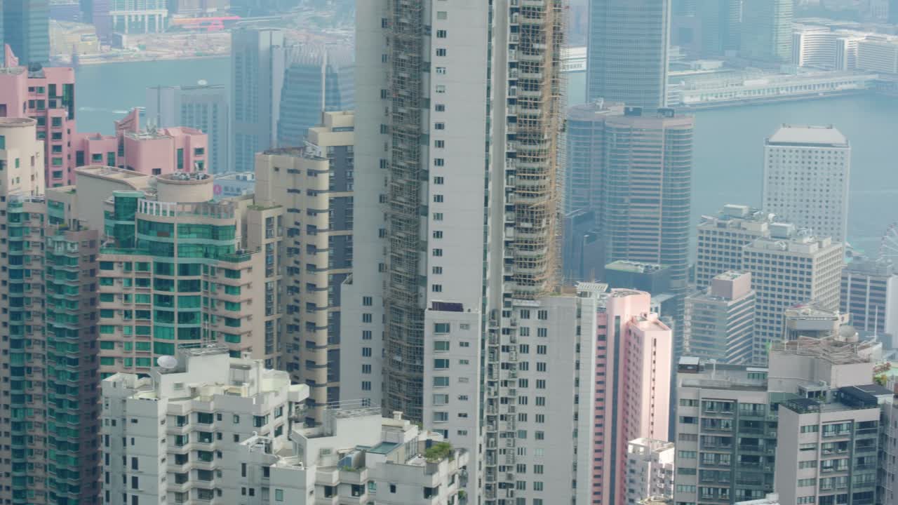 Vista urbana panorâmica do centro de Hong Kong do miradouro do Victoria Peak num dia ensolarado, exibindo o denso horizonte e o Porto de Victoria.