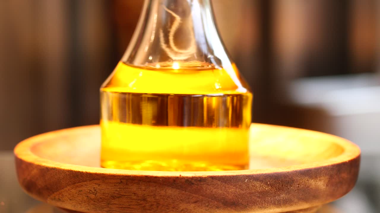 Bottle of olive oil and olive leaves on yellow ,