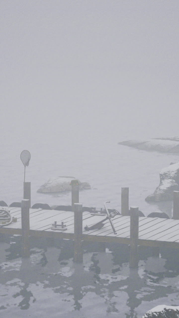 Misty winter dock with snow and icy water in a tranquil setting