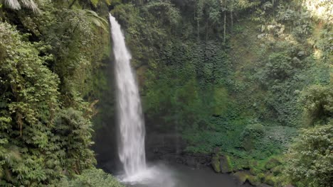 a drone captures the magnificence of the nungnung waterfall in bali, indonesia as water falls to the pool below