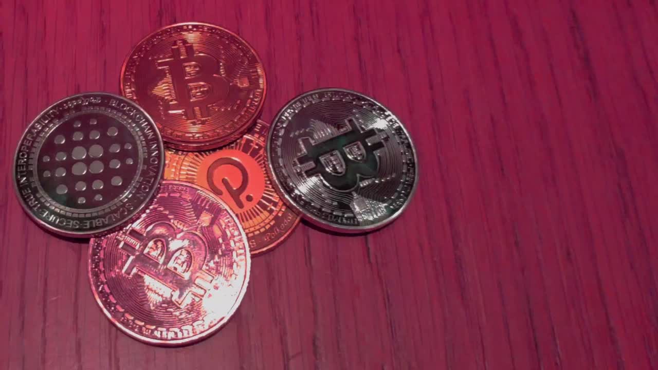 monedas bitcoin y polkadot en color rojo que representan el mercado bajista volátil en blockchain web 3, pagos digitales, reflejos de luz, toma macro en primer plano rodando desde arriba, galicia, españa
