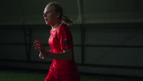 young athlete practicing soccer skills indoors