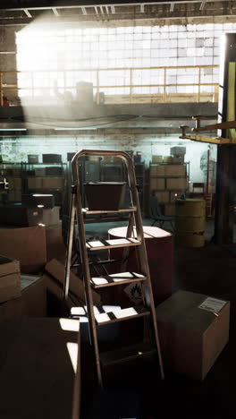 a dusty and empty industrial warehouse with a ladder in the middle