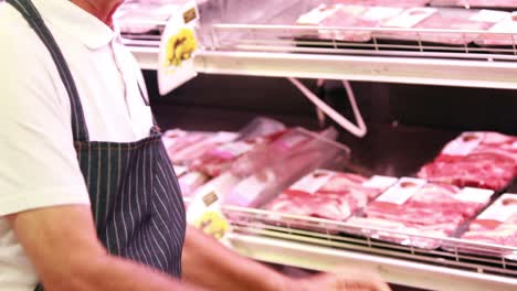 senior worker stocking fridge in the supermarket