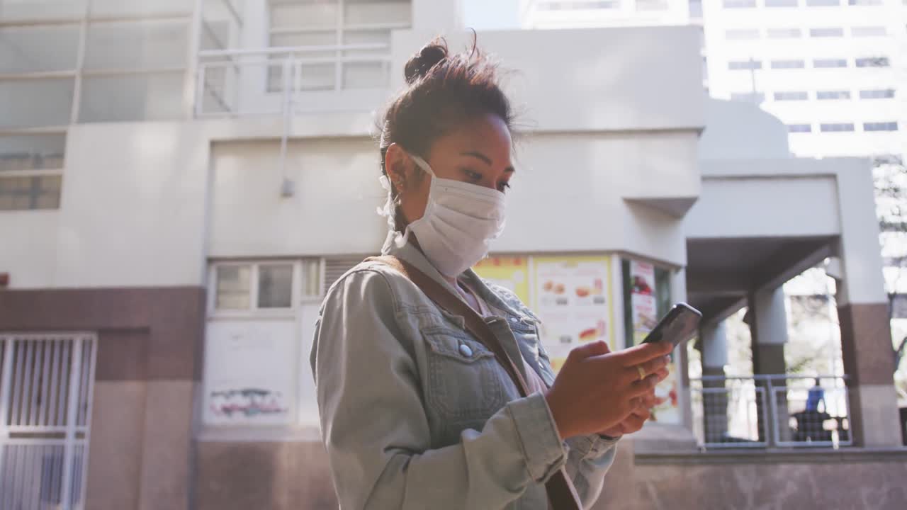 Mixed race woman wearing medical coronavirus mask on the street