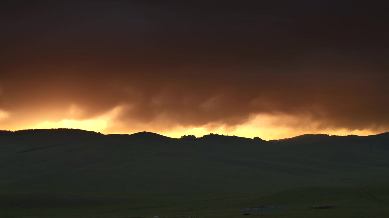Dramatic Sunset Over Rolling Hills With Dark Storm Clouds