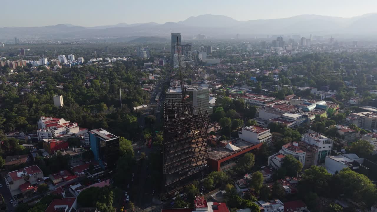 Orbital drone view of a skyscraper under construction with cranes in Mexico City