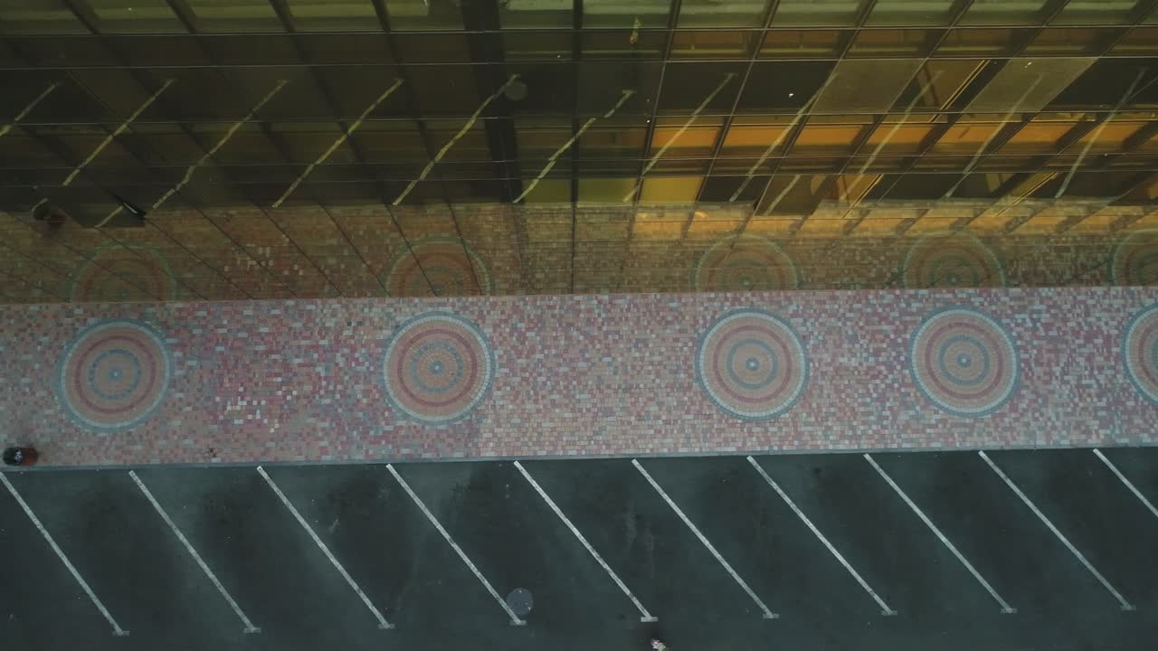 4k vista exterior de la torre del edificio del distrito comercial o centro comercial con ventanas de espejo de pared en el día. vista de la cámara desde alto hermoso diseño exterior de adoquines coloridos o pavimentación de piedra.