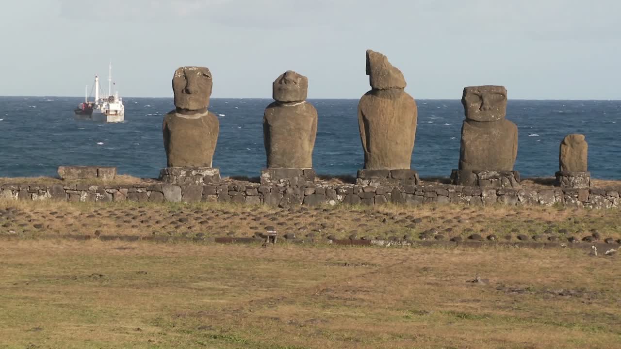 estatuas rotas en la isla de pascua con un barco