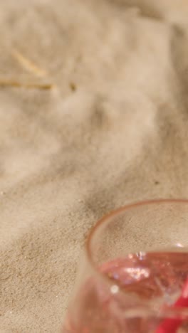 Vertical-Video-Summer-Holiday-Concept-Of-Sunglasses-And-Cold-Drink-On-Sandy-Beach