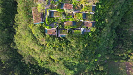 villas nestled on mountain terrace with private pools in tropical wild nature environment of nusa penida bali at maua resort, aerial establishing view