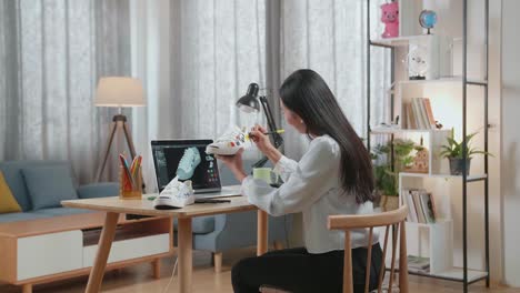 노트북에서 운동화를 디자인하는 여자