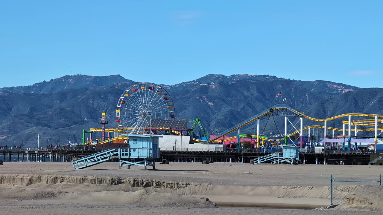 Large rotating ferris wheel on Santa Monica Pier in Los Angeles on a sunny day