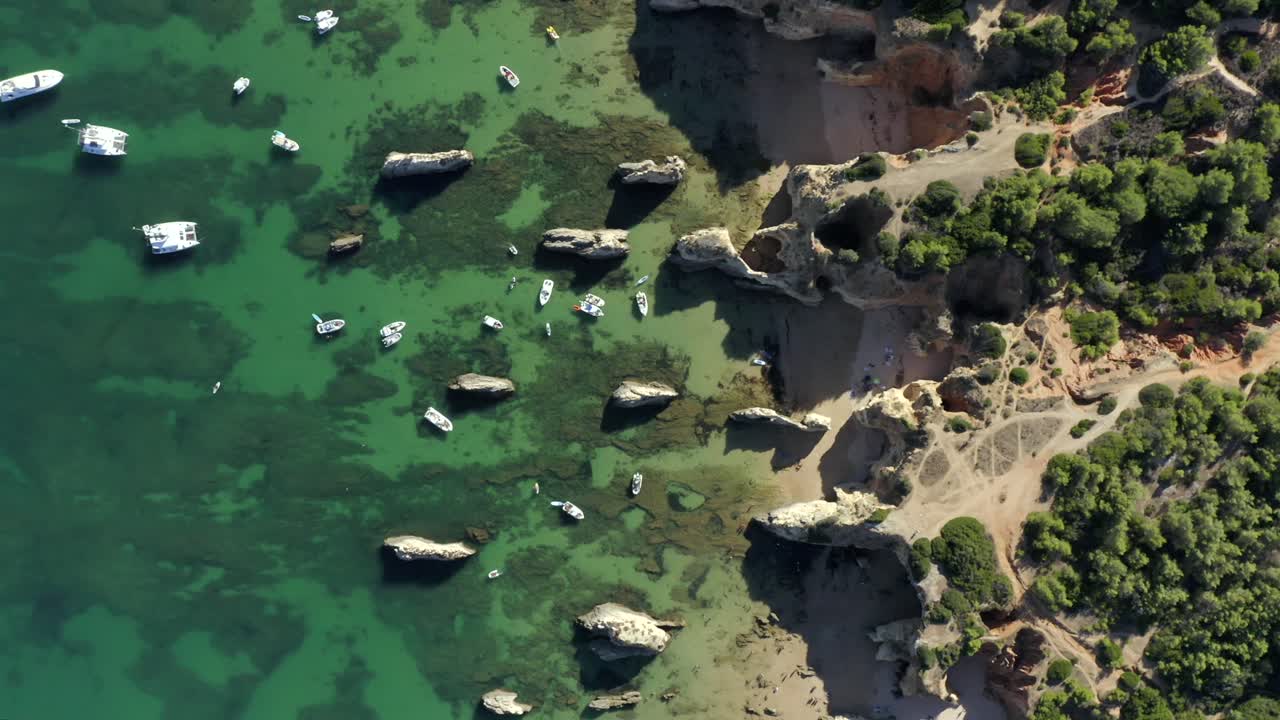 아름다운 해안선 경치를 배경으로 호화로운 열대 요트 위로 날아가는 감각적인 버드아이 공중