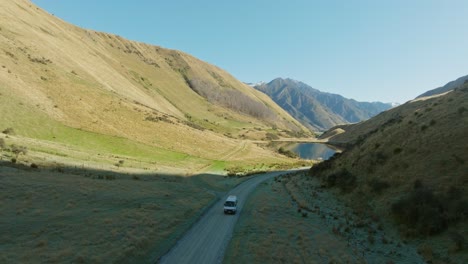 vista aérea panorámica de la caravana y el impresionante lago moke rodeado de un paisaje montañoso escarpado y escarpado en otago, isla sur de nueva zelanda aotearoa