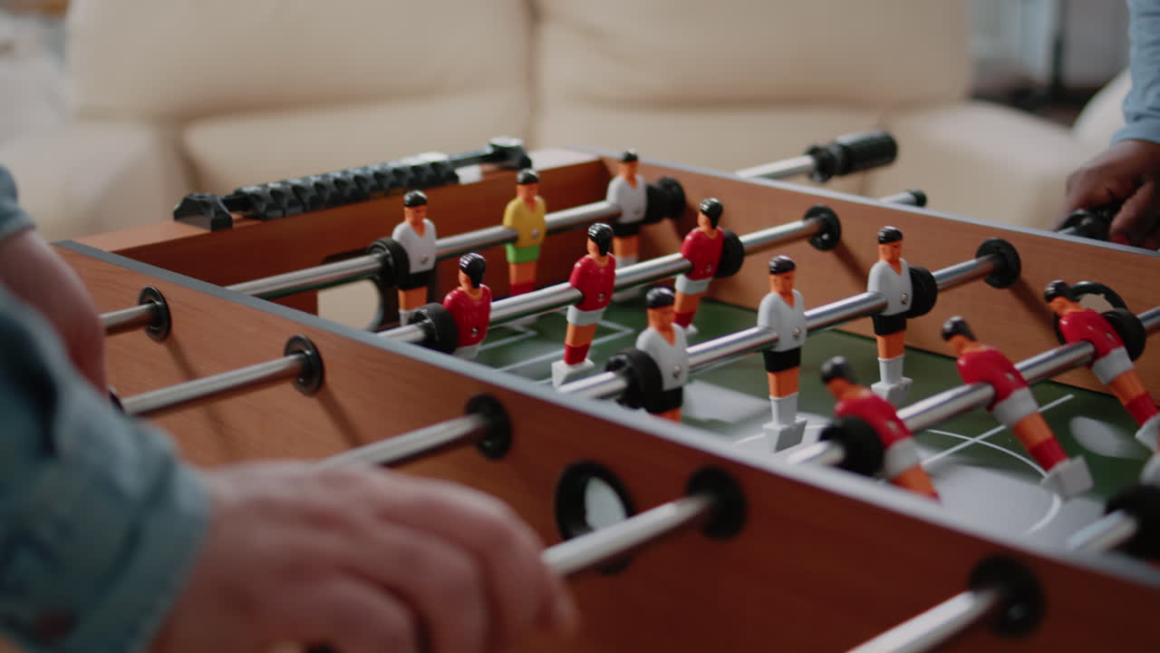 Close up of coworkers using foosball game table for fun