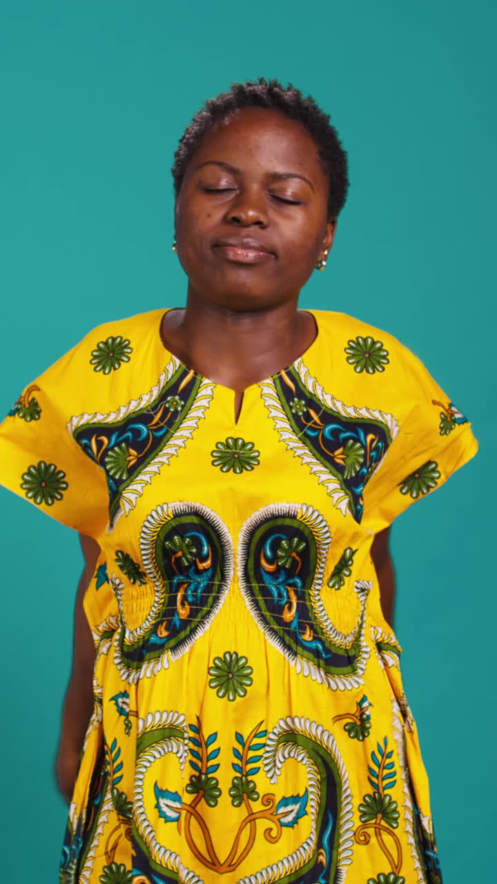 Donna africana rilassata in abito tradizionale che si allunga