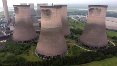 disused industrial energy power plant cooling smoke stake chimneys aerial view orbit right high angle