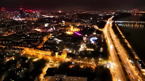 descending drone shot of warsaw center in the night with vistula river