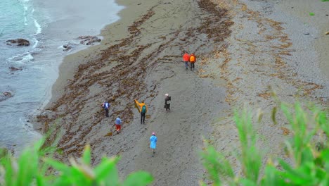 people walking on a rocky beach