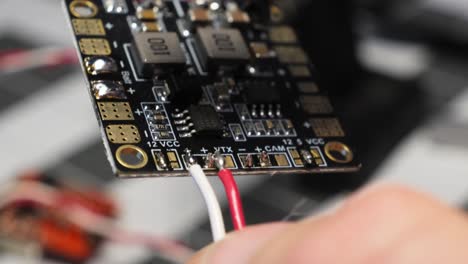 Electrician-soldering-wire-to-circuit-board-at-workbench,-closeup-soldering-iron-diy-electronic-repair