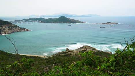 Aerial-wide-shot-showing-beautiful-ocean-landscape-with-bay,beach-and-mountains-in-background