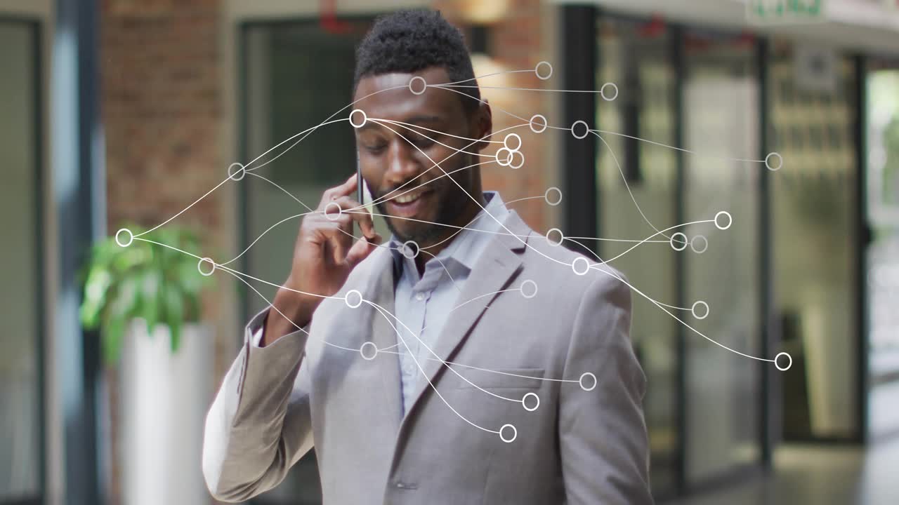 Erhvervsperson går i lobbyen, taler i telefon og aktiverer animerede datanoder, der visualiserer et netværk