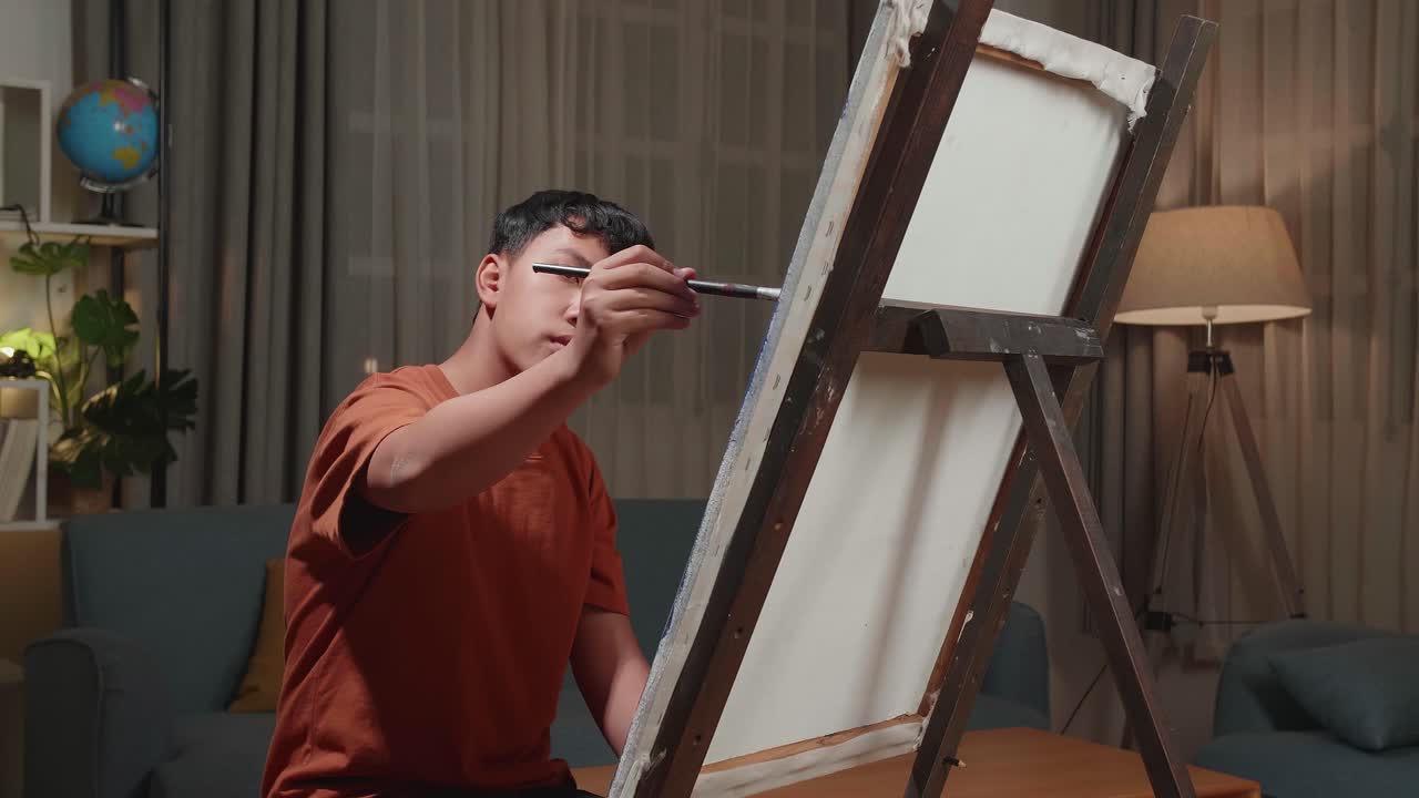 Asian Artist Boy Holding Paintbrush Mixed Colour And Thinking Before Painting On The Canvas