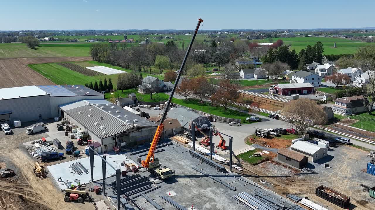Aerial shot of a construction site with crane and steel beams in rural Pennsylvania showcasing industrial activity vibrant colors rich detail cinematic quality