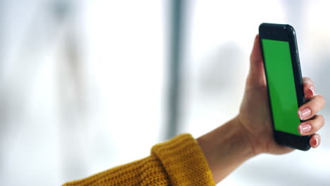 brunette woman holding smartphone with green screen. girl making video talk