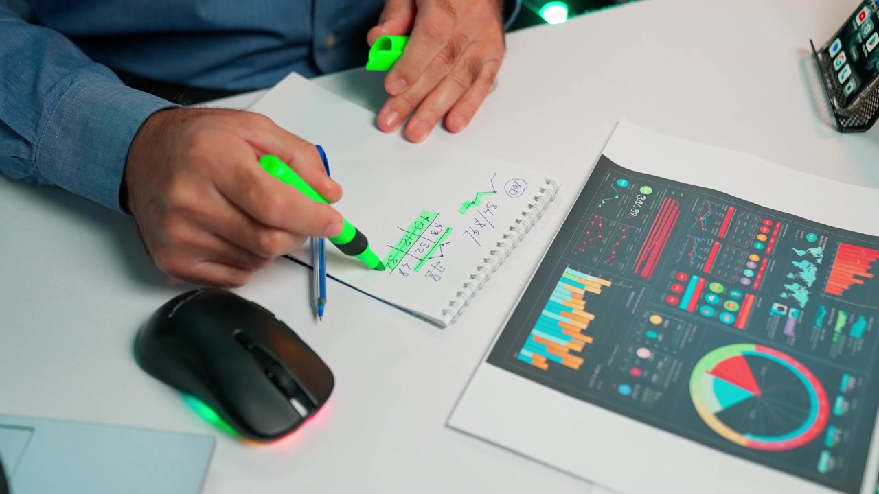 Person Highlighting Data and Charts on an Office Desk