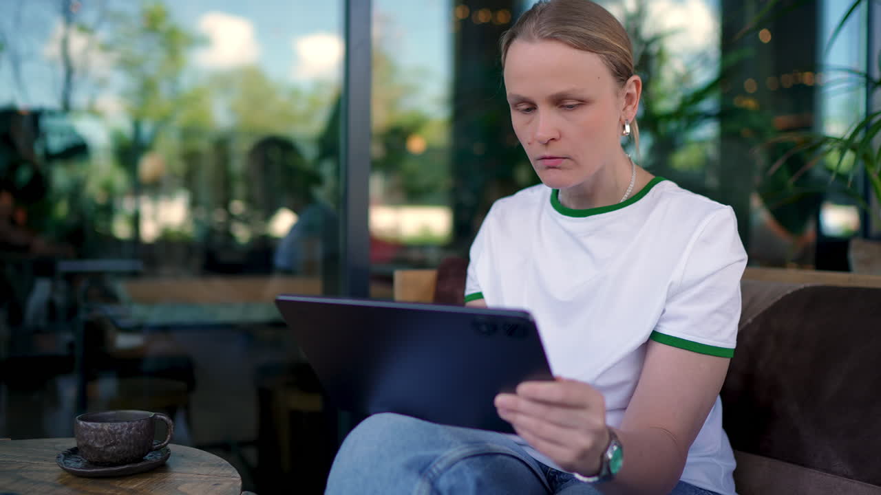Woman reaching for coffee while working