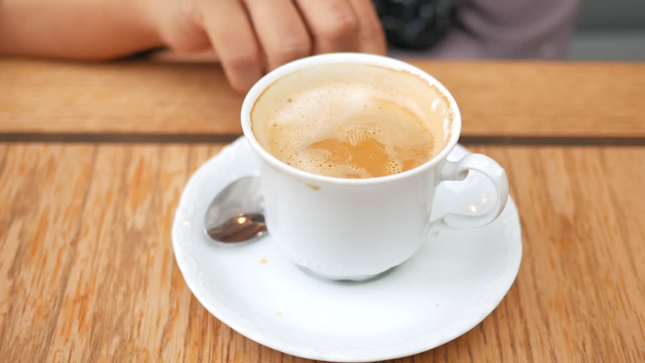 una taza blanca de café en una mesa de madera