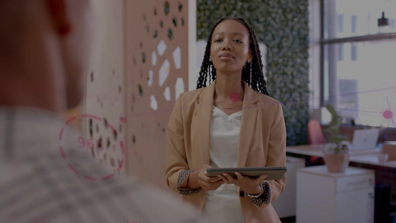 Woman presenting tablet in office reacting to man gesturing while pink marks appearing on panel